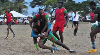 Leading from the front! Captain Patrick King tackling an opposing UG player during the seesaw game yesterday at the campus ground. (Orlando Charles photo)  