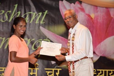 President David Granger handing over a certificate to valedictorian and Guyana’s top performer at this year’s CSEC, Victoria Najab. (Ministry of the Presidency photo) 