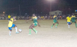 Darren Harris of Pele (left/yellow) trying to evade the impending challenge of GDF’s Selwyn Isaacs during their matchup at the Camp Ayanganna ground in the GFF Stag Beer Elite League