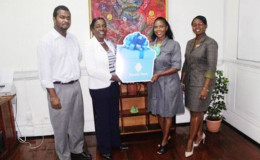 Minister within the Ministry of Education, Nicolette Henry (second from left) receiving the cheque from Republic Bank manager Celine Davis. (Department of Culture, Youth and Sport photo)