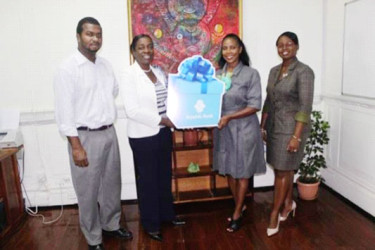Minister within the Ministry of Education, Nicolette Henry (second from left) receiving the cheque from Republic Bank manager Celine Davis. (Department of Culture, Youth and Sport photo) 