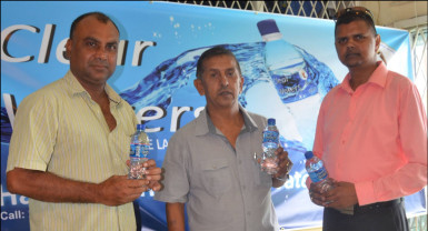 Marketing, Sales and Distribution Manager of Clear Waters, Narendra Lucknauth (right), GFSCA President Ramchand Ragbeer (centre) and Vice-president of the GFSCA, Ricky Deonarain, display a bottle of Clear Waters. 