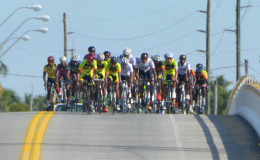 The peloton going full throttle over the Abary Bridge in yesterday’s second stage. (Orlando Charles photo)