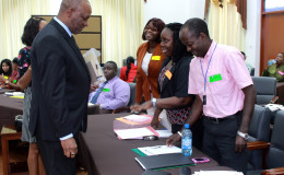 Minister of State, Joseph Harmon (left)  interacting with some of the public servants
