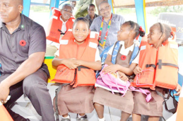 President David Granger and Co-Chairman of CGX Energy Incorporated Professor Suresh Narine sit with students in a new school boat just before its first official journey on the Pomeroon River yesterday. The president presented the boat, named ‘David G II,’ to the children of the Upper Pomeroon as part of his initiative to ensure all children across the country have access to transportation to get to school. See story on page 17. (Ministry of the Presidency photo) 
