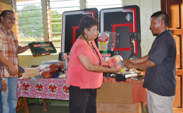Minister Ally hands over one of the items to Sports Chairman at Kurupukari, Mark Holden (GINA photo)