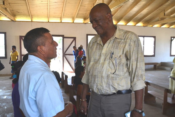Minister Joseph Harmon (right) interacts with a resident of Sand Creek, Region 9. (Minister of the Presidency photo)