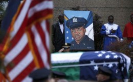 The casket of slain New York City Police (NYPD) officer Randolph Holder passes a painting of Holder, as it is carried from the Greater Allen A.M.E. Cathedral of New York following his funeral service in the Queens borough of New York City, October 28, 2015.  REUTERS/Shannon Stapleton