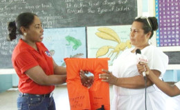 MARAD’s Public Relations Officer, Akousa Mc Pherson (left) hands over one of the lifejackets to Muritaro Primary School teacher Sharmin Grey. (GINA photo)
