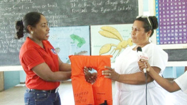 MARAD’s Public Relations Officer, Akousa Mc Pherson (left) hands over one of the lifejackets to Muritaro Primary School teacher Sharmin Grey. (GINA photo) 