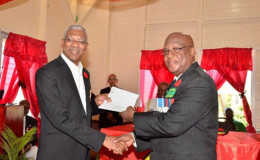 President David Granger (left) handing over cheques in the amount of $4.8M to President of the Guyana Veterans Legion, Lt. Col. (ret’d), George Gomes. (GINA photo)
