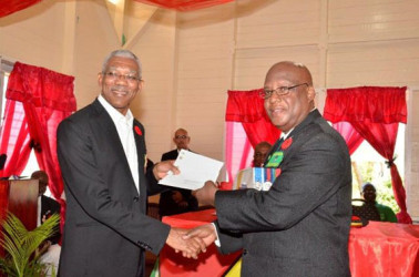 President David Granger (left) handing over cheques in the amount of $4.8M to President of the Guyana Veterans Legion, Lt. Col. (ret’d), George Gomes. (GINA photo) 