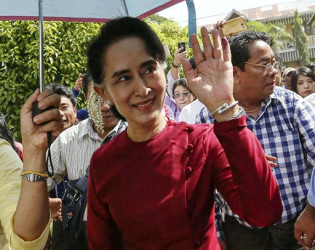 Myanmar pro-democracy leader Aung San Suu Kyi waves at supporters as she visits polling stations at her constituency Kawhmu township November 8, 2015. REUTERS/Soe Zeya Tun 