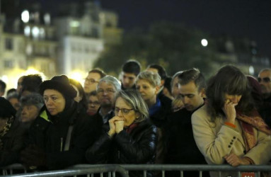 People gather outside Notre Dame Cathedral where a mass was held following a series of deadly attacks in Paris, November 15, 2015.  Reuters/Gonzalo Fuentes 