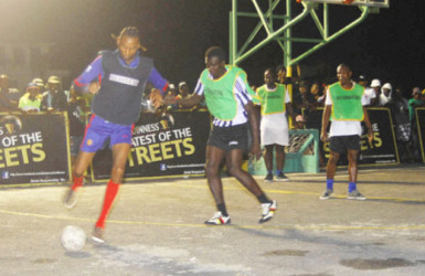 Sparta Boss’s Dennis Edwards (left) trying to maintain possession of the ball while being challenged by a Gold Star player during his side’s win in the Georgetown leg of the Guinness of the Streets at the Burnham Court Tarmac 