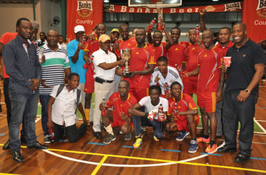 Captain of the Banks DIH Phillip Rowley receiving the championship trophy from the Minster of Foreign Affairs Carl Greenidge following their hard-fought win over the Ministry of Foreign Affairs in the final of the inaugural Banks Beer Inter-Corporation Futsal event