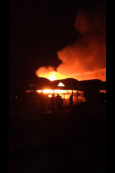 Students look on as fire rages through a building in the Faculty of Natural Sciences at the Turkeyen Campus. 