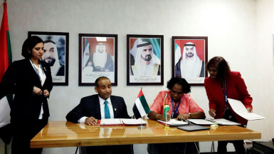 Minister Annette Ferguson (second from right) signing the agreement 
