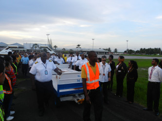 The body of late Captain Alvin Winston Clarke is led through an honour passage at the Cheddi Jagan International Airport yesterday. (Roraima Airways Inc photo)