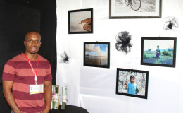 Photographer Brian Gomes showcases some of his other framed photos which were on sale at his booth at the Business Expo. 