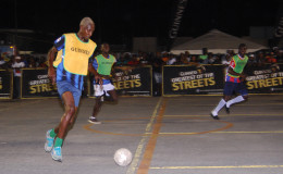 Colin Daniels of defending champs, North Ruimveldt in the process of initiating an attack on the Leopold Street goal during their team’s matchup in the Guinness Greatest of the Streets Georgetown Championship at the Demerara Park Tarmac.