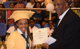 Minister of State, Joseph Harmon handing over a certificate and $50,000 cheque to Shontay Noel on President David Granger's behalf. Noel graduated from the St. Roses High School earlier today. The ceremony was held at the Arthur Chung Convention Centre. (GINA photo)