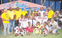 The newly crowned Courts Pee Wee u-11 champions St. Angela’s posing with their championship accolade after defeating Enterprise in the grand finale on Tuesday while members of Courts Guyana Inc., the National Sports Commission, the Ministry of Health, Banks DIH Limited and the Petra Organization share the moment.