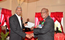 President David Granger (left) handing over cheques in the amount of $4.8M to President of the Guyana Veterans Legion, Lt. Col. (ret’d), George Gomes (GINA photo)