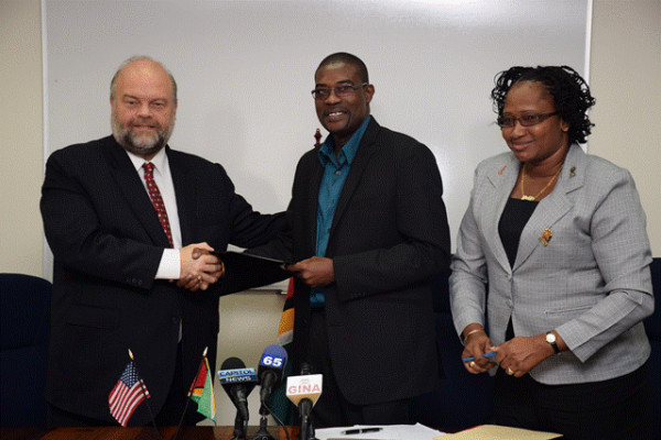 Minister of Public Infrastructure David Patterson (centre) and US Ambassador to Guyana Perry Holloway shake hands following the signing of the MOU between the GCAA and USA-TSA at the Ministry’s boardroom, Wight’s Lane.  Also in photo is Minister within the Ministry of Public Infrastructure Annette Ferguson (GINA photo) 