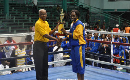 Barbados’ Kimberley Gittens receiving her female best boxer trophy of the Caribbean Development Goodwill Tournament which concluded Sunday night at the Cliff Anderson Sports Hall.
