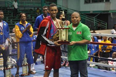 Trinidad and Tobago’s Aaron Hackett receiving his best boxer award when the curtains came down on the Caribbean Development Goodwill Tournament Sunday night at the Cliff Anderson Sports Hall 