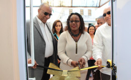 Minister Simona Broomes cuts the ribbon to re-commission the Guyana Gold Board’s Bartica office while Ministers Harmon (at left) and Trotman look on. (Government Information Agency photo).