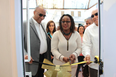 Minister Simona Broomes cuts the ribbon to re-commission the Guyana Gold Board’s Bartica office while Ministers Harmon (at left) and Trotman look on. (Government Information Agency photo).