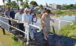 Minister of Social Cohesion Amna Ally (right) and residents on the bridge constructed by the De Kinderen Community Group (GINA photo)
 
