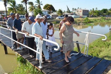 Minister of Social Cohesion Amna Ally (right) and residents on the bridge constructed by the De Kinderen Community Group (GINA photo)   