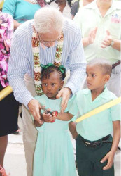 Minister of Education, Dr Rupert Roopnaraine with pupils of the Cummings Park Nursery at the symbolic cutting of the ribbon (Ministry of Education photo) 