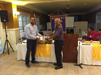 Dr Kenneth Jainandan (left) handing over the supplies to Ron Robinson