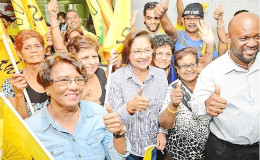 Re- elected United National Congress ( UNC) political leader Kamla Persad-Bissessar (centre) celebrates with supporters following her victory in the UNC internal election at her Penal constituency office on Saturday night. 