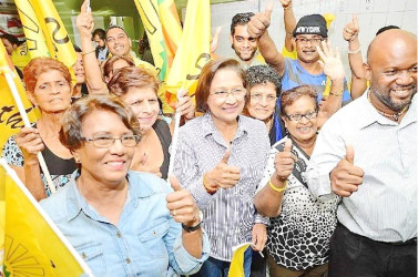 Re- elected United National Congress ( UNC) political leader Kamla Persad-Bissessar (centre) celebrates with supporters following her victory in the UNC internal election at her Penal constituency office on Saturday night. 