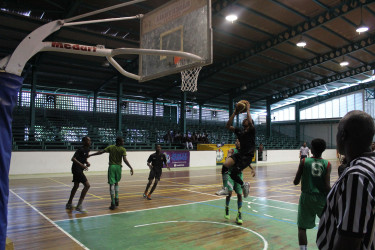 Zion Gray of Tutorial High in the process of scoring against the Bishops High during their u-15 encounter in the YBG Youth-Level Championship at the Cliff Anderson Sports Hall