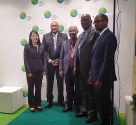 Minister Raphael Trotman (second from left) with the team from Global Green Initiative after the signing. (Ministry of the Presidency photo) 