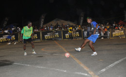 Gregory Richardson (right) of Sparta Boss in the process of attempting a forward pass while being marked by North Ruimveldt’s Travis Grant during their team’s semi-final encounter at the National Cultural Centre Tarmac in the Guinness of the Streets Georgetown Championship.