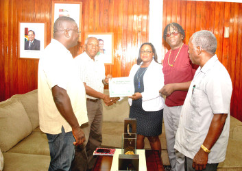 GCAG representatives receiving their Certificate of Registration from Minister Simona Broomes. 