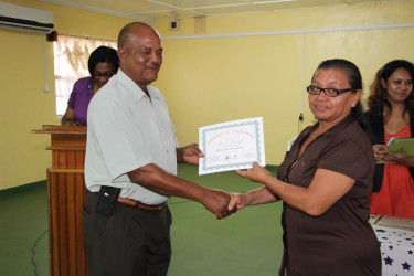 Regional Executive Officer, Carl Parker, presents a certificate to Theresa Mansingh at the closing ceremony of the ‘Self-Reliance and Success in Business’ workshop, held at the Indigenous Peoples Conference Hall in Lethem. (Ministry of the Presidency photo)