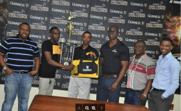 Sparta Boss captain Devon Millington (2nd from left) collects the championship trophy and package from Guinness Representative Shawn Stephney while other members of Banks DIH and Petra Organization including Guinness Brand Manager Lee Baptiste (3rd from right) and Petra Organization Director Troy Mendonca (left) look on.
