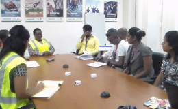 Minister within the Social Protection Ministry, Simona Broomes (third, left) and her team talking to some of the Qualfon staff, at Qualfon Goedverwating