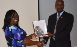 Minister in the Ministry of Public Health Dr Karen Cummings receiving a copy of the strategy from Dr Martin Odiit, UNAIDS Country Coordinator (GINA photo)
