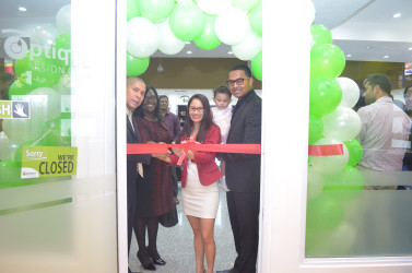 Cutting the ribbon for the opening of Optique Vision Care in Giftland Mall. (From left are Minister of Public Health, Dr. George Norton, Minister within the Ministry of Public Health, Dr. Karen Cummings and Madonna Narine, Co-founder of Optique (centre) ,Manager, Dhani Narine and their daughter, Madison Narine.