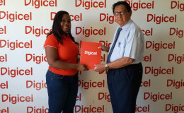 Digicel’s Sponsorship Executive, Louanna Abrams, and president of Kennard’s Memorial Turf Club, Cecil Kennard, pose for a photo during the ceremonial handing over of support on Wednesday at Digicel’s Head Office.
