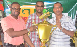 UDFA President Sharma Solomon receives the first place trophy from Ramesh Sunich of Trophy Stall while Jeoff Clement GT Beer Brand manager looks on.
